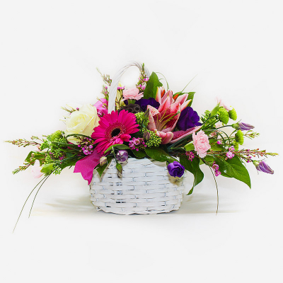 A Basket that Delights - A delightful basket arrangement of pinks, creams and purple mixed with complementary foliage.
