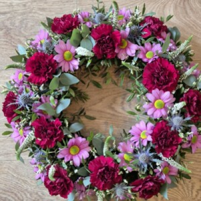 Wreath in purple  - A beautiful fresh flower wreath in deeper colours which are carefully selected by the florist. Other colours are available- yellows, lilacs, orange, reds ect just ask for details. 