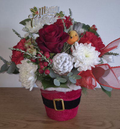 Santa pot - Lovely selection of fresh flowers and Christmas greens displayed in a cute Santa pot.
