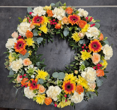Autumn Wreath - A beautifully handcrafted wreath in warm cream, golden yellow and apricot tones, thoughtfully arranged with seasonal flowers to create a heartfelt and uplifting tribute.